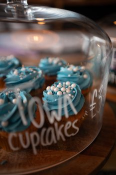 A photo of some cupcakes in a jar marked "Town Cupcakes £3.50". The cupcakes have blue icing and white pearls on top.